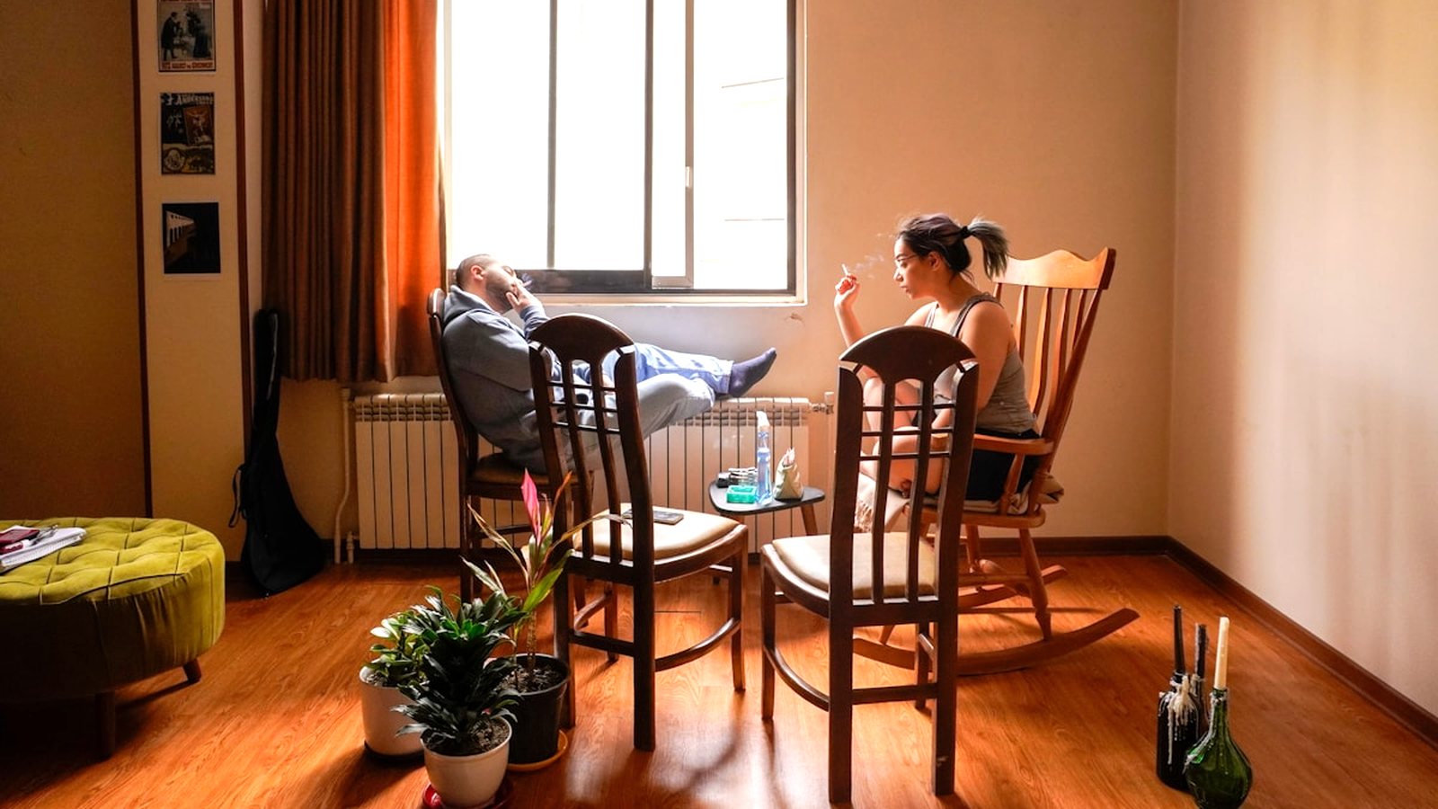 Dwoje dorosłych rozmawia w jasnym, przytulnym pokoju pełnym roślin