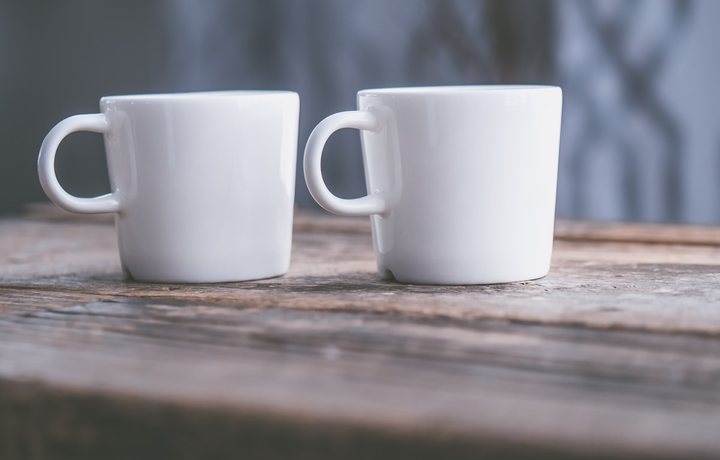 Dwa kubki na stole — spokojna rozmowa przy wstępnej konsultacji